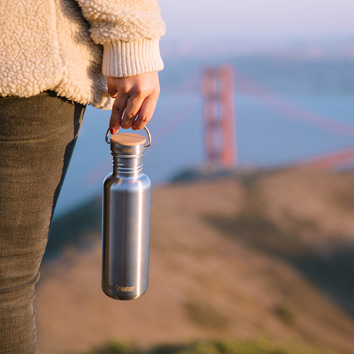 27oz-reflect-with-bamboo-cap-o5 K27SSLRF-BS-BAMBOO_reflect_bottle_bridge_lifestyle.jpg